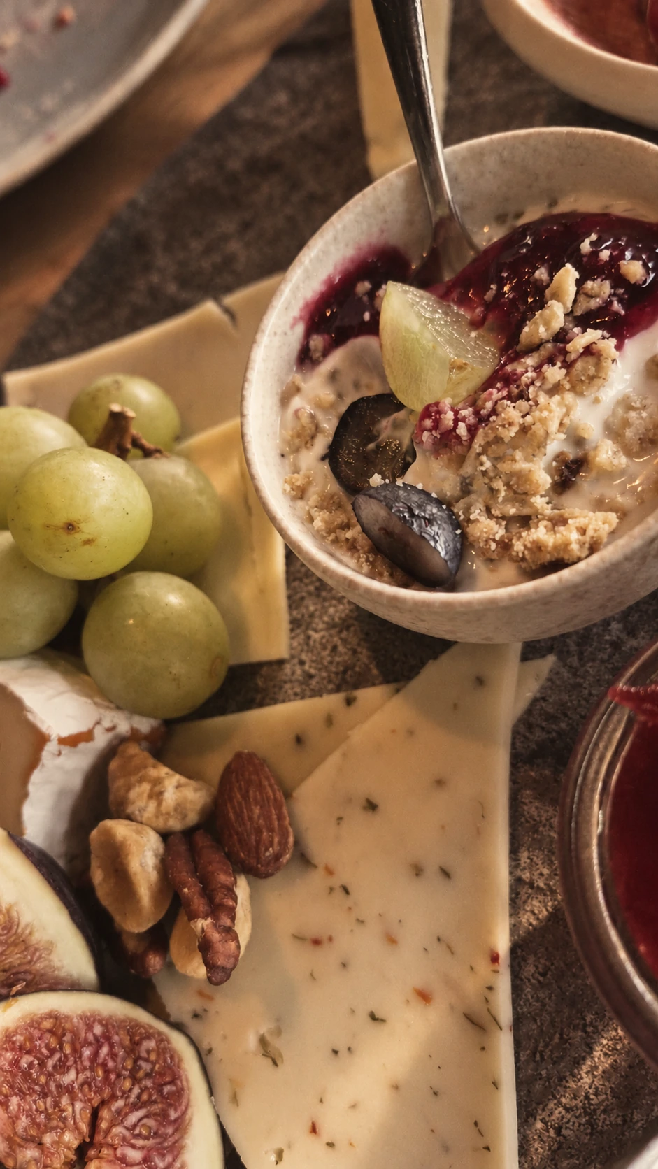 Frühstücksbrett mit Feigen, Käse und Beerenschale im warmen Licht