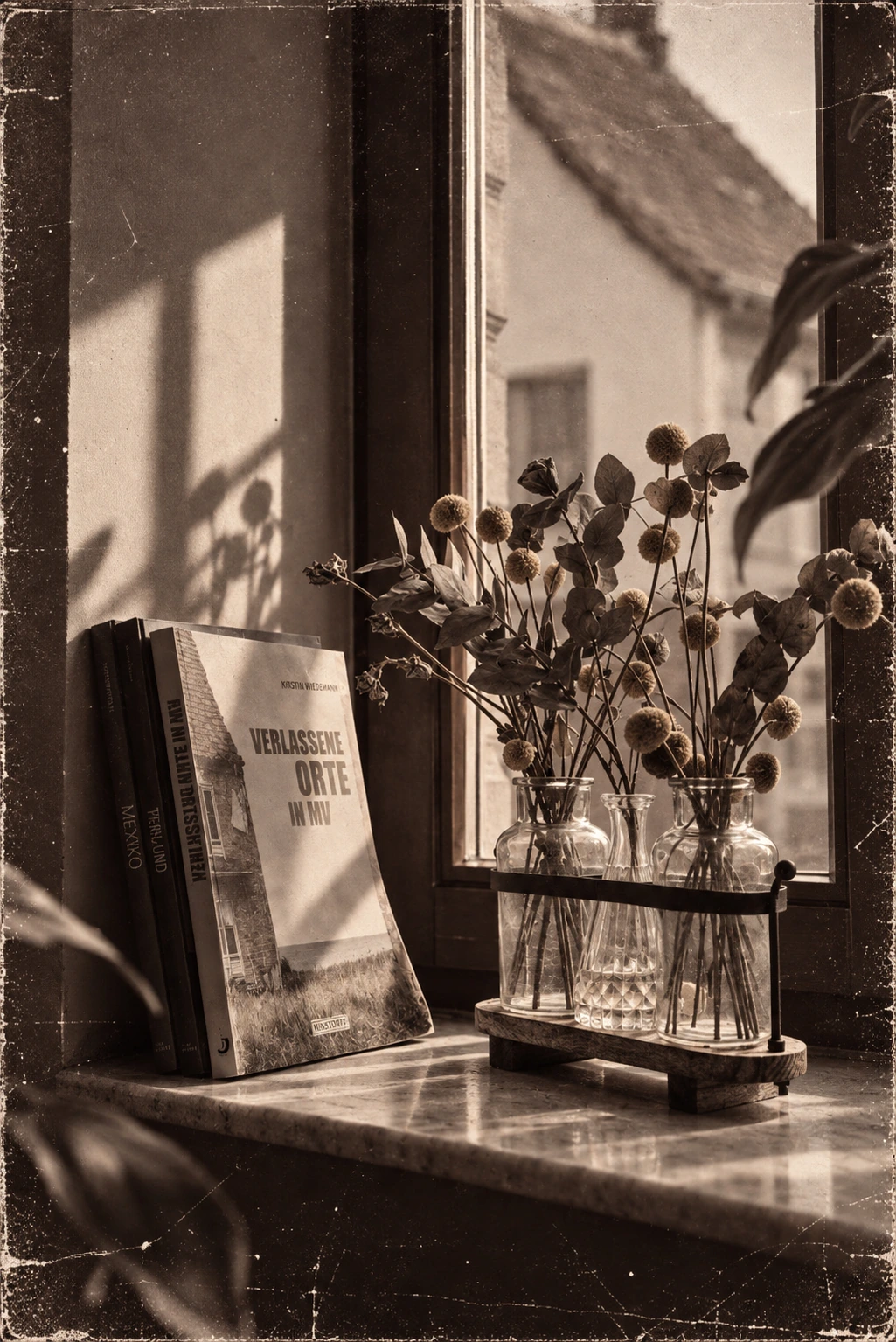 Blumen und Buch auf der Fensterbank im warmen Licht